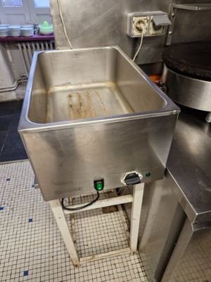 stainless steel sink in a commercial kitchen next to a stove