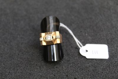 une bague noire et dorée sur laquelle est accrochée une étiquette blanche