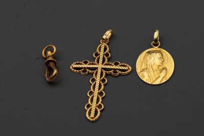 deux croix dorées et une pièce de monnaie sur fond noir
