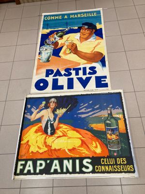 Deux affiches représentant un homme et une femme sont posées sur un sol carrelé.