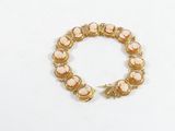 une photo d'un bracelet en or orné de pierres roses
