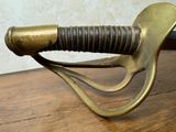 a close up of a sword on a wooden table