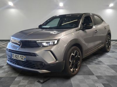 un SUV argenté garé dans une pièce au sol en damier