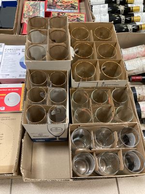 des cartons contenant des verres à vin vides et des bouteilles de vin posés sur une table