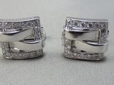 une paire de boucles d'oreilles manchette en or blanc et diamants sur fond blanc