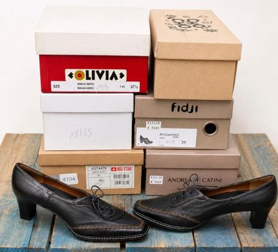 several boxes of shoes sitting on top of a wooden table