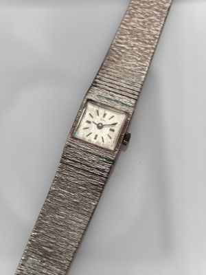 a close up of a watch on a white surface with a white background
