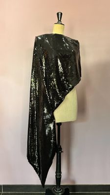 a black sequinned shawl on a mannequin stand