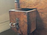 a small wooden box on the side of a bed