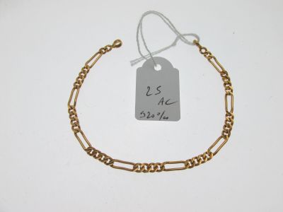 Gros plan sur un bracelet en chaîne en or portant une étiquette