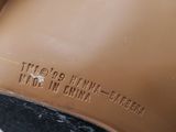 a close up of a brown shoe on a white surface