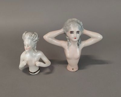 two figurines of a woman sitting next to each other