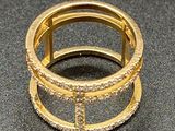 gold plated ring with clear stones on a black surface