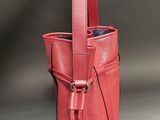 a red handbag with a strap on the handle