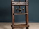 un vieux meuble en bois surmonté d'une machine, dans une pièce