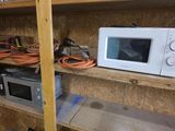 un micro-ondes et un four à micro-ondes posés sur une étagère dans une pièce