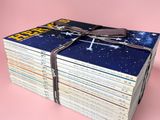 une pile de livres « Star Wars » sur fond rose