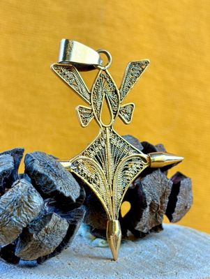 brass plated pendant with a bird on top of a pine cone