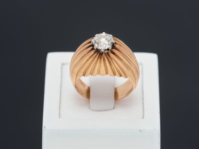 gros plan d'une bague en or surmontée d'un diamant