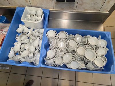 deux bacs posés par terre, contenant des assiettes et des bols