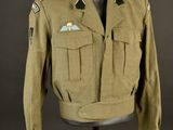 an army uniform on a mannequin stand with a black background