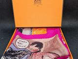 une boîte orange contenant une paire de chaussettes sur laquelle figure l'image d'une femme