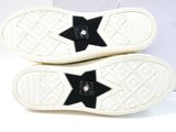 black and white sneakers with black stars on the soles
