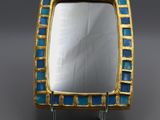 a close up of a blue and gold ring on a gray surface