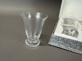 a small glass vase sitting next to a small glass cup