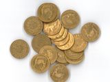 une pile de pièces d'or posée sur une surface blanche