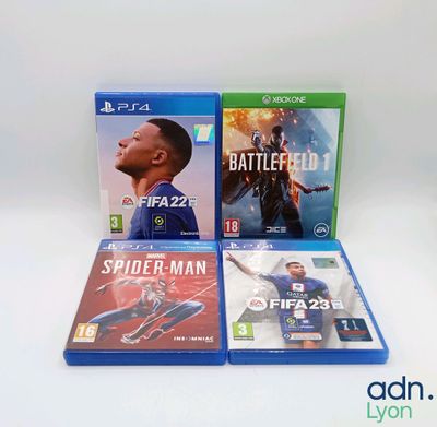 three video games are sitting on a white surface, one is a spider - man and the other is a