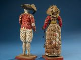 two figurines of a man and a woman dressed in period clothing