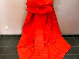 an orange dress hanging on a hanger in a room