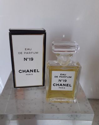 Flacon et coffret du parfum Chanel n° 19 posés sur une table en marbre