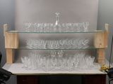 a glass shelf with a lot of glasses on it