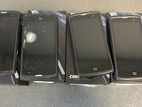 quatre téléphones portables sont posés en rang sur une table