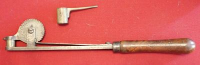a metal tool with a wooden handle on a red surface