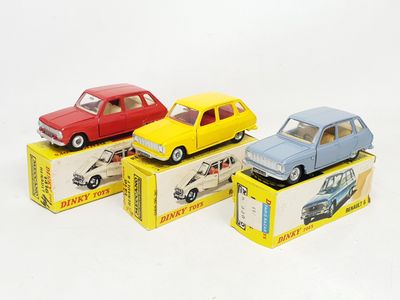 quatre petites voitures posées sur des cartons, sur une surface blanche