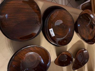 de nombreux bols et casseroles en bois accrochés au mur