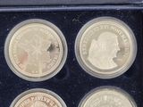 three silver coins in a black box with a picture of a man and a woman