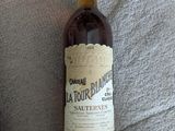 une bouteille de vin posée sur un lit, à côté d'une autre bouteille de vin