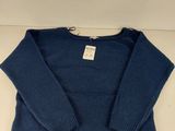 the sweater is blue and has a white tag on it