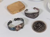many different types of jewelry on a white table