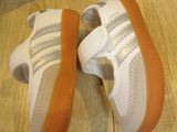 a pair of white and orange shoes on a wooden floor