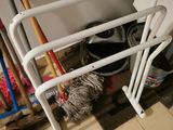 a white rack with brooms and a mop on it