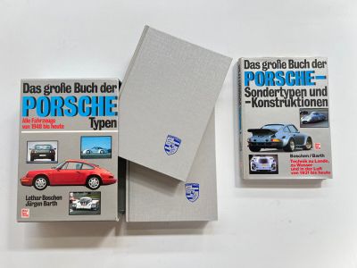 three books on a white surface with a red car in the background