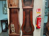two grandfather clocks sitting next to each other in a room