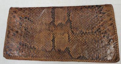 an image of a brown snake skin purse on a white surface
