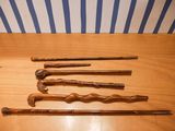 four wooden canes are lined up on a wooden table