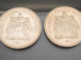 two silver coins, one of which is a woman and one of which is a man